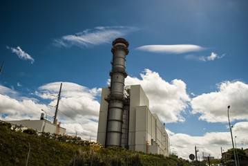 F&aacute;brica bajo el cielo azul y nubes. 