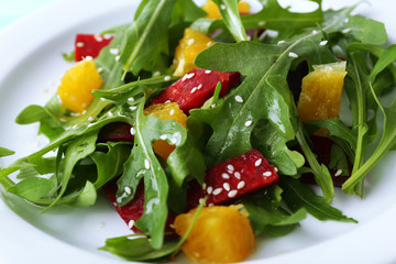 Tasty salad with arugula leaves in plate, closeup