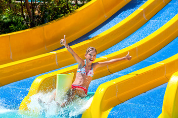 Child in bikini sliding water park.