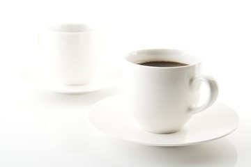 Cups of coffee with saucer on white