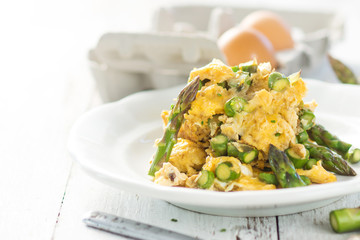 Green asparagus and eggs on wooden background