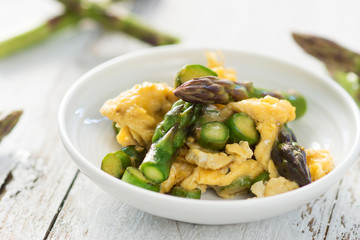 Green asparagus and eggs on wooden background