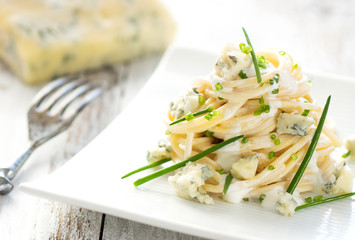 Pasta with gorgonzola on a wooden background