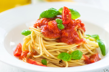 Spaghetti with tomato and basil leaves and chilli