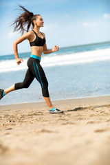 Fototapeta na wymiar Sportswoman running outdoors on blue sea