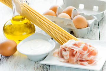 Spaghetti carbonara with all ingredients on the wood background