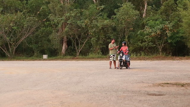 instructor explains right way of driving scooter to girl	