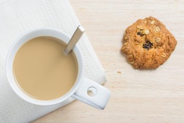 Coffee and cookies on a table in a top view.