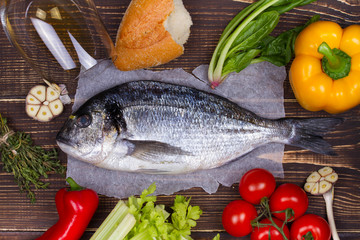 Delicious fresh fish and vegetables on dark vintage background