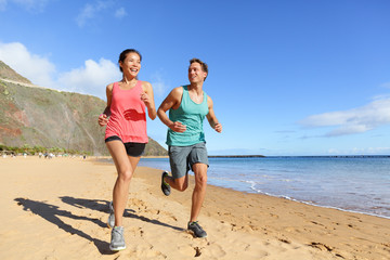 Runners running on beach - jogging couple