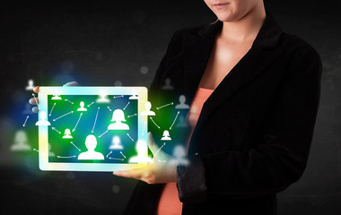 Young person presenting tablet with green social media icons