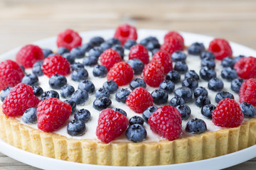 Cake with blueberries and raspberries. Confectionery product.