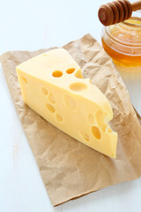 Cheddar cheese on a paper with honey