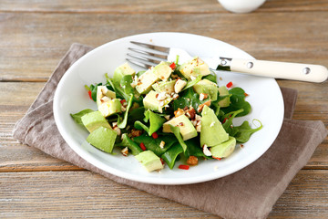 Salad with avocado, spinach and nuts in a bowl