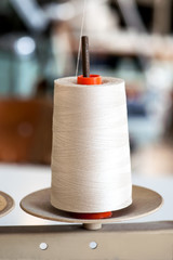 White thread roll on a stand for sewing