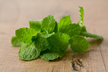 fresh mint leaves on wooden surface