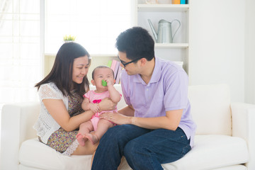 asian parent playing with baby girl in livingroom