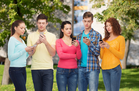 group of serious teenagers with smartphones