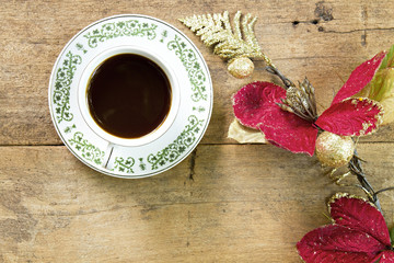 Coffee with red flower on wooden plank background