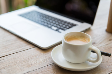 close up of laptop and coffee cup on office table