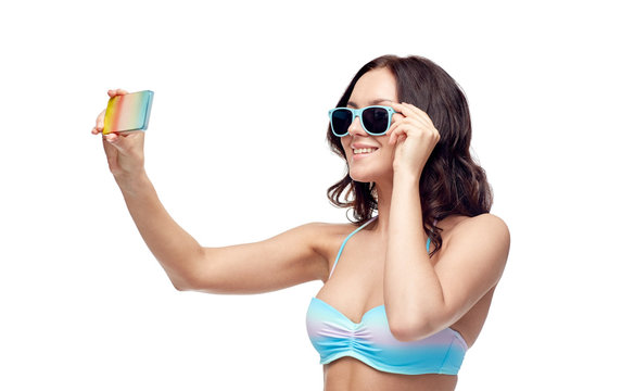 woman in swimsuit taking selfie with smatphone