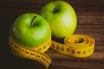 Green apples with measuring tape