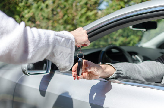 Woman giving car key to a man