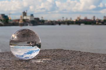 Glass transparent ball on city background and grainy surface