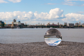 Glass transparent ball on city background and grainy surface
