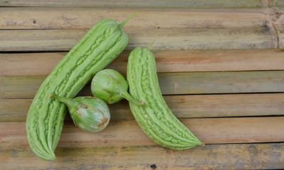 bitter gourd and egg plant on bamboo desk