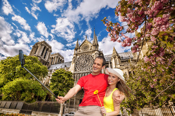 Obraz premium Couple Taking Selfie by Notre Dame cathedral in Paris, France