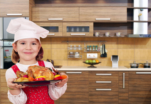 little girl cook with chicken in kitchen