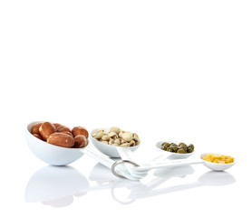 Beans in measuring spoons on white background