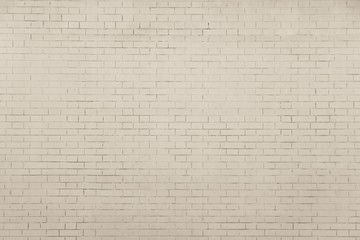 the pale beige textured surface of a brick wall