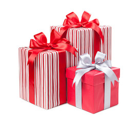 Red and striped boxes with gifts tied bows on white background