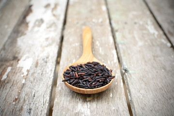 Close up of riceberry in spoon on old wooden
