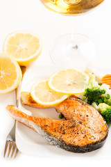 Grilled salmon and vegetables on plate with wine