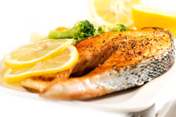 Grilled salmon and vegetables on white with selective focus
