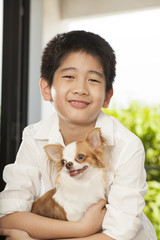 kid life, an Asian boy hug his Chi hua hua tiny dog