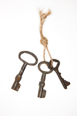 A lot vintage keys on a rope on white background