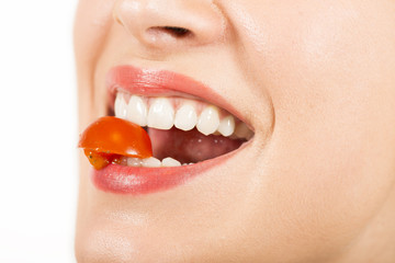 Close up portrait of woman eating cherry tomatoes. 