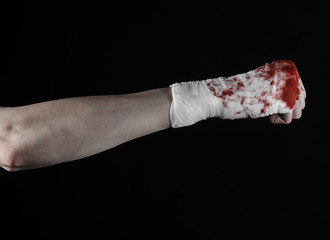 bloody hand in a bandage, bloody bandage, black background © Alex