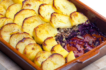 potatoes baked with pork minced meat and red cabbage
