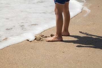 Children legs on the sea beach