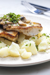 pikeperch on butter with mushroom sauce and spring potatoes