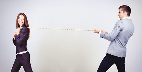 Business people stretching rope on grey background