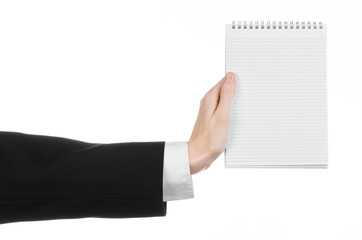hand of a journalist in a black suit holding a notebook
