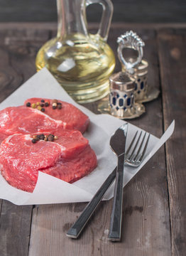 Marbled beef steak with a bottle of olive oil and salt