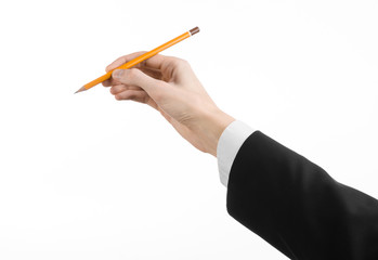 hand of the artist in a black suit holding a pencil isolated