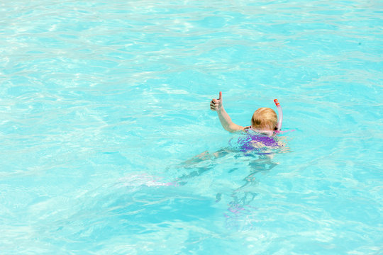 little girl snorkeling in swimming pool